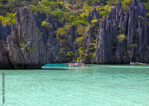 Landscape with philippino boat, rocks and blue bay. El Nido, Palawan