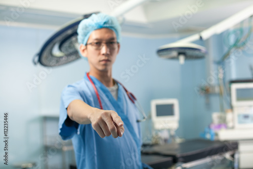 doctor said  a male doctor point at the camera in the operation room with all equipment