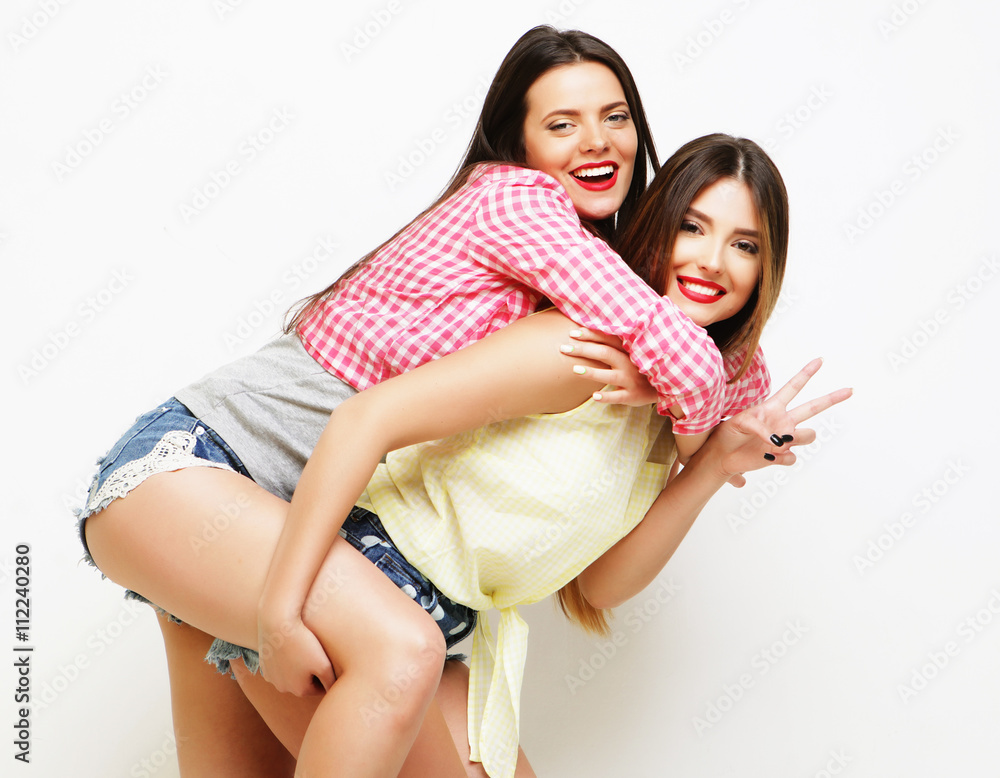 Two fashion laughing painted girl friends hugging and having fun Two fashion laughing painted girl friends hugging and having fun