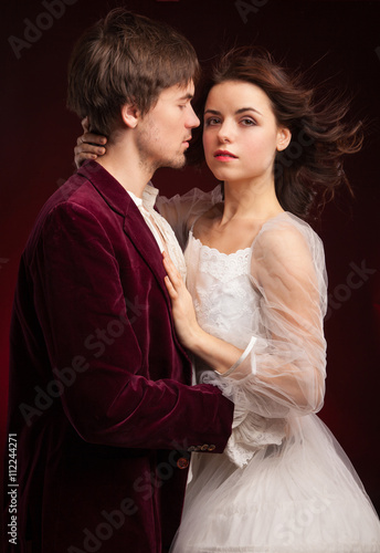 pretty young lady in old time and man in red medieval dress 