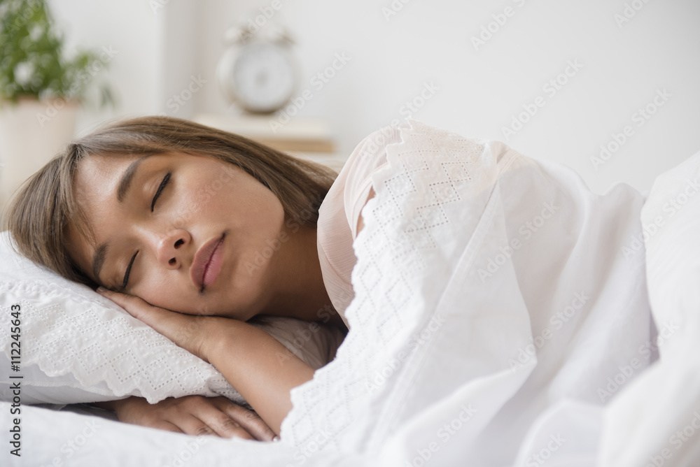 Mixed race woman sleeping in bed Mixed race woman sleeping in bed