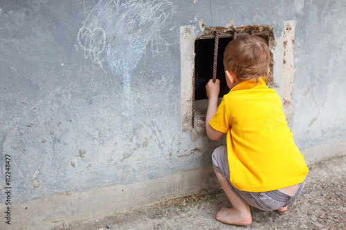 Konstfotografi curious child looks into the barred window