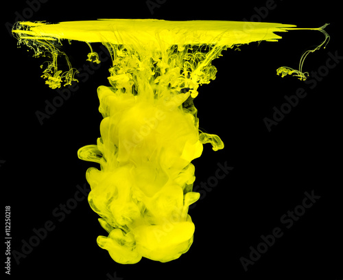 Yellow ink in water creating abstract shape