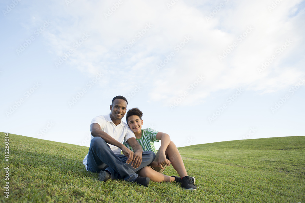 Father and son sitting in grass Father and son sitting in grass