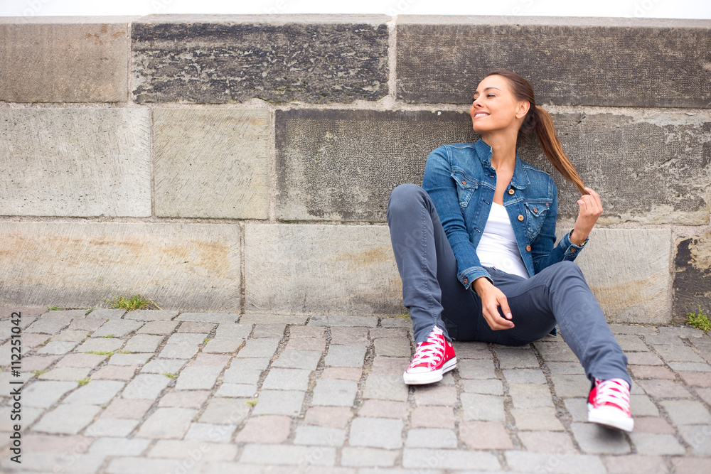 young woman sitting on the floor enjoying her day. young woman sitting on the floor enjoying her day.