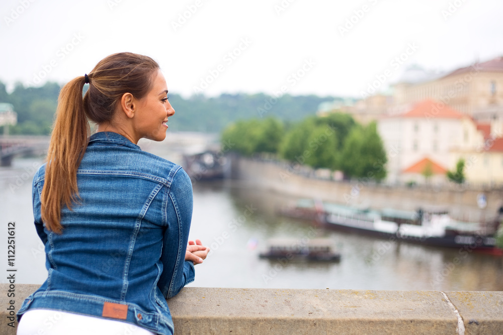 young woman enjoying the view from a bridge