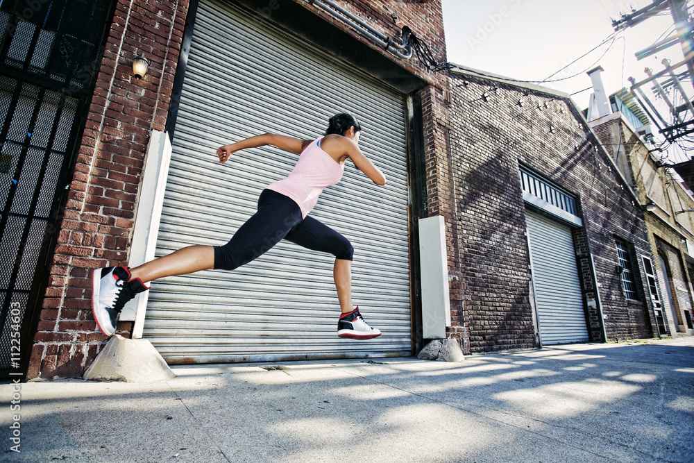 Mixed race woman running on sidewalk Mixed race woman running on sidewalk
