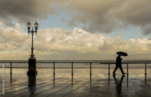 Hombre con paraguas paseando por la ciudad