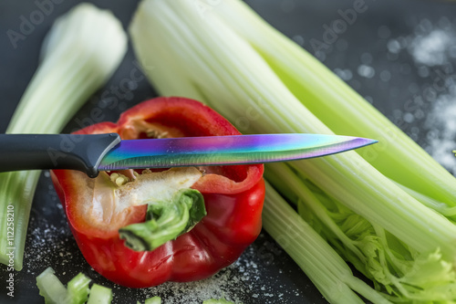 red pepper, salt, celery and the knife on the table