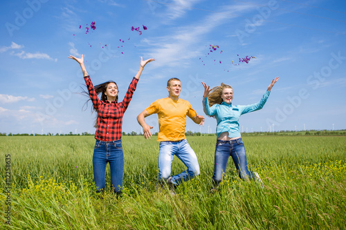 Young happy Friends running on green wheat field