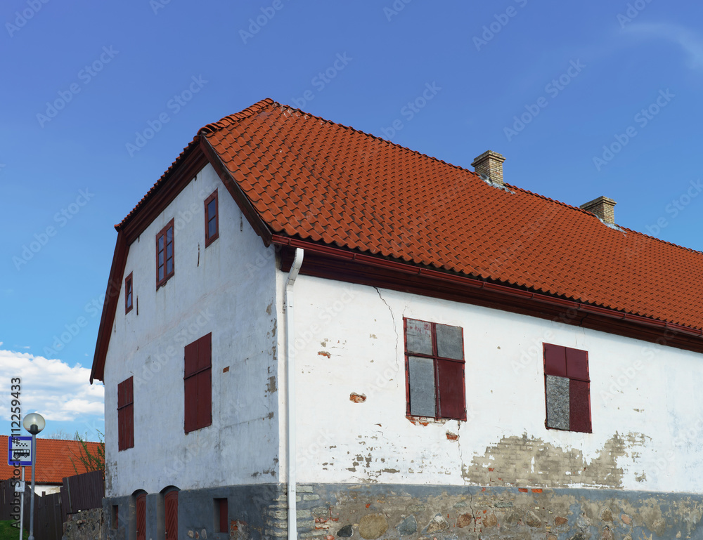 White painted Old house with red roof in Ventspils