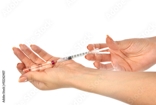 Doctor hands with medical syringe with needle in ampule