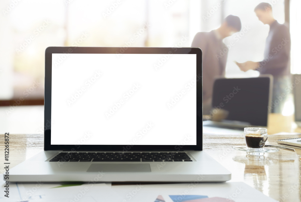 Laptops on desk in office with morning light on blur business te Laptops on desk in office with morning light on blur business te