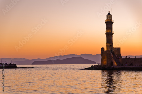 Panoramic view of the entrance to Chania harbor with lighthouse at sunset, Crete, Greece