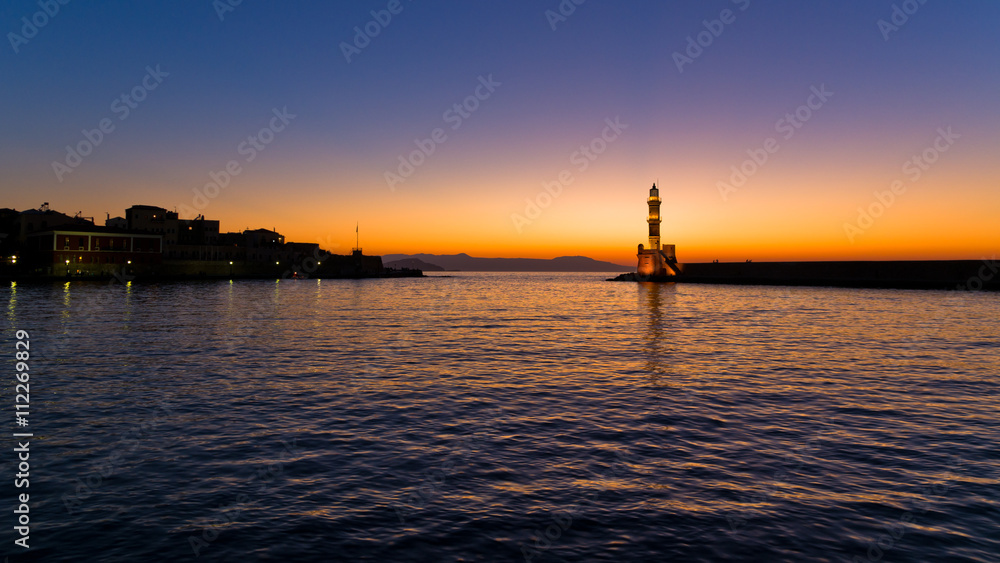 Panoramic view of the entrance to Chania harbor with lighthouse at sunset, Crete, Greece Panoramic view of the entrance to Chania harbor with lighthouse at sunset, Crete, Greece