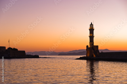 Scenic view of the entrance to Chania harbor with lighthouse at sunset, Crete, Greece