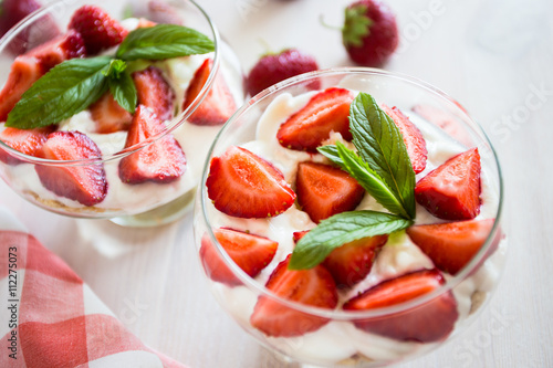 Layered dessert of strawberries, biscuit and ice cream in a glass