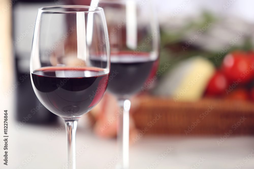 Fototapeta premium Glasses of red wine with food on table closeup