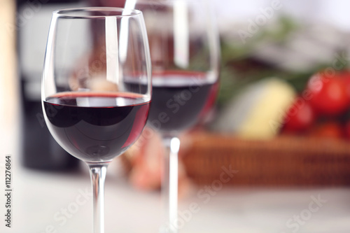 Glasses of red wine with food on table closeup