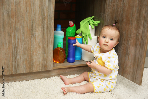 Photos Little girl playing with detergents in kitchen