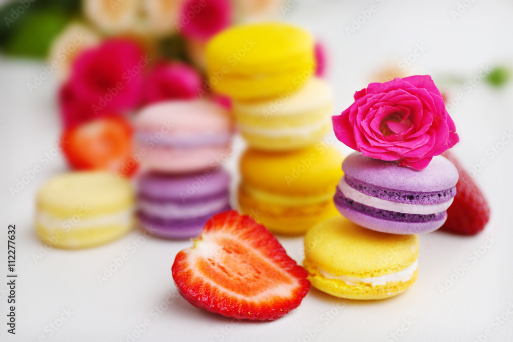 Macaroons with roses and strawberries on white background Macaroons with roses and strawberries on white background