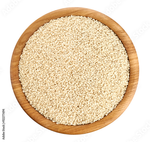 Wooden bowl with sesame seeds isolated on white background.