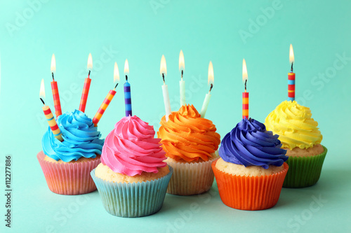 Birthday cupcakes with candles on turquoise background