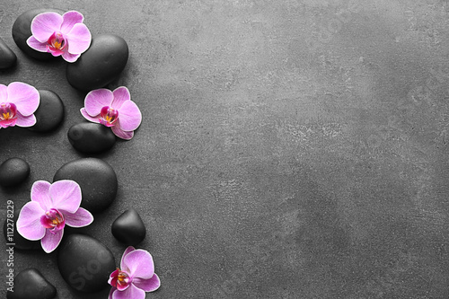 Spa stones and orchids on dark background
