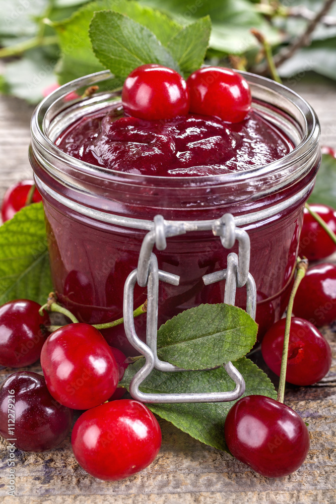 Domestic fresh cherry jam on a rustic wooden board Domestic fresh cherry jam on a rustic wooden board