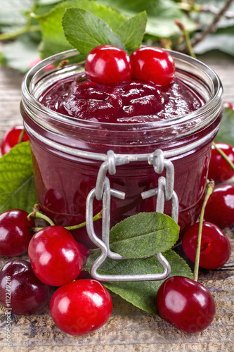 Domestic fresh cherry jam on a rustic wooden board