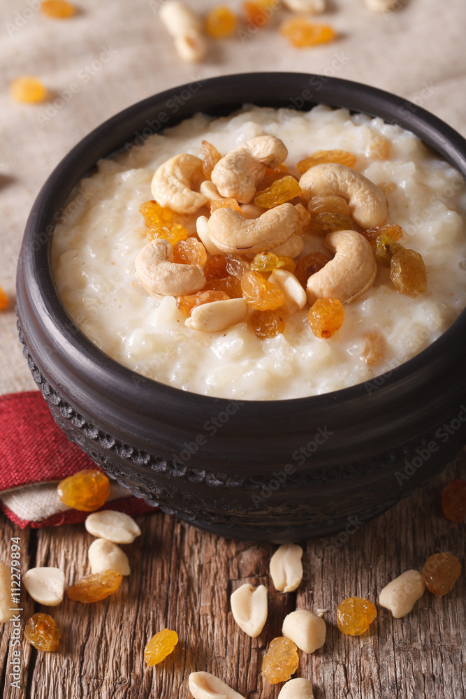 Indian cuisine: kheer rice pudding with nuts and raisins close-up. vertical
Indian cuisine: kheer rice pudding with nuts and raisins close-up. vertical