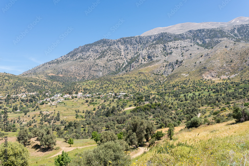 On the old road to Rethymnon in springtime. View to the mountain village Kouroutes on Crete. In the background, the Ida mountain range with the Psiloritis as the highest elevation on Crete 