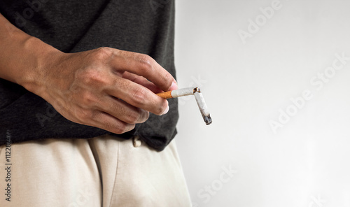 Photos Hand holding burning break cigarette