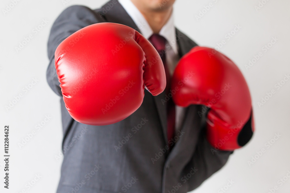 Businessman in boxing gloves launching a punch isolated on white background Businessman in boxing gloves launching a punch isolated on white background