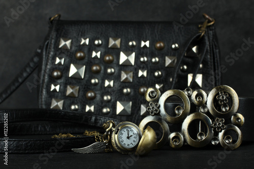 Foto women's bag with old clocks as a pendant on a black background