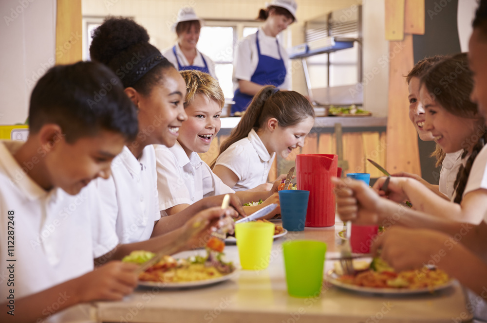 Primary school kids at a table in school cafeteria, close up Primary school kids at a table in school cafeteria, close up