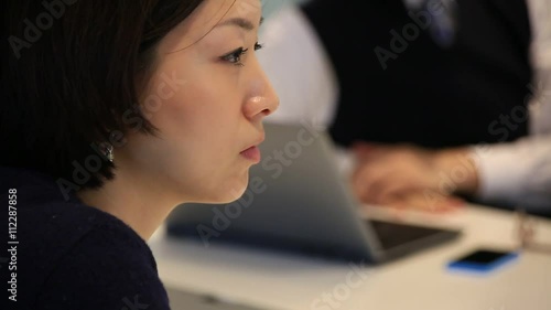 Business woman listening and nodding during corporate presentation