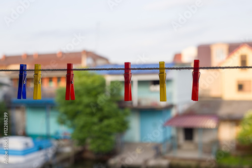 Colorful clothespins hanging in line at yellow house background