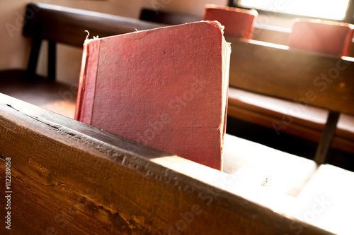 Bild auf Leinwand The old red books or red worship songbooks in church
