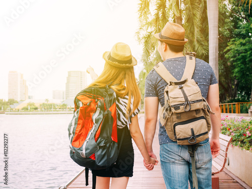 Couple travelers walking and holding hands together - Journey of love and travel