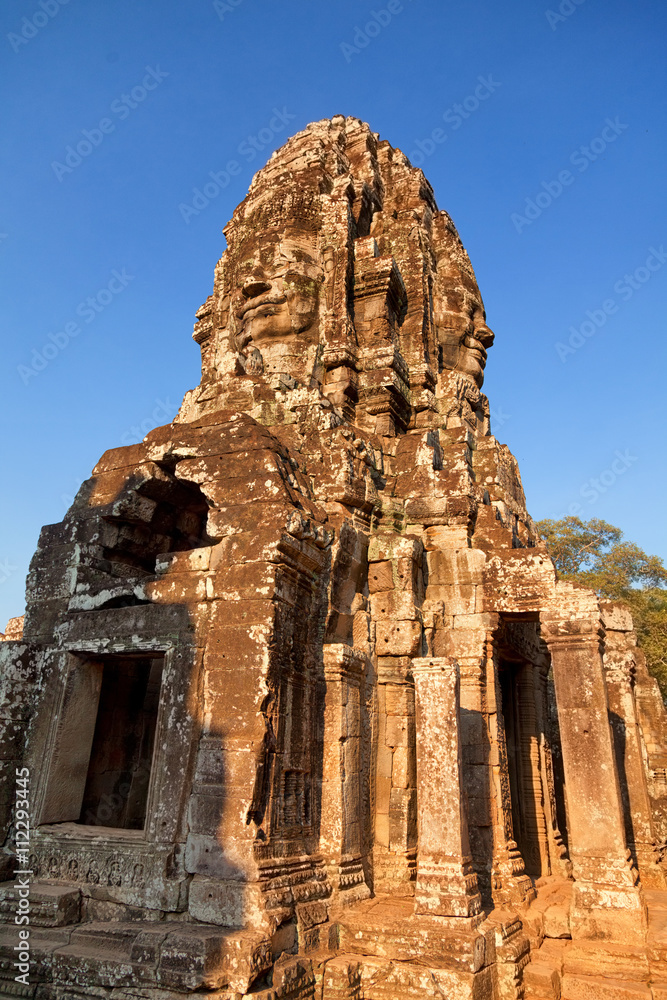 Stone carved face of Bayon Temple in Angkor Thom, Angkor district, Siem Reap, Cambodia. Full length view Stone carved face of Bayon Temple in Angkor Thom, Angkor district, Siem Reap, Cambodia. Full length view