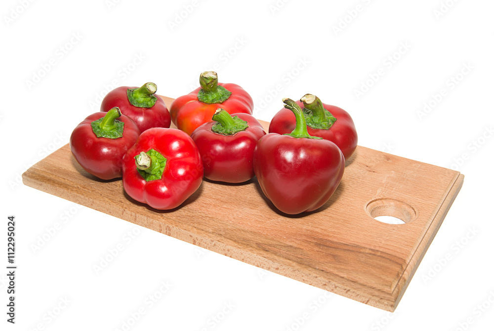 Several peppers on a wooden cutting board. Several peppers on a wooden cutting board.