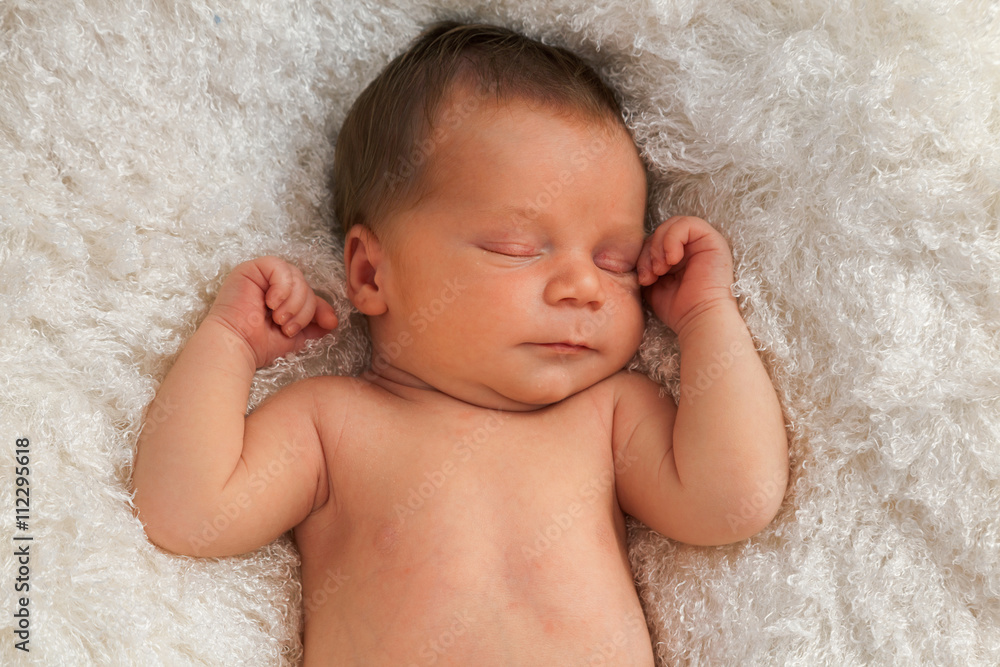 One week old baby sleeping on white blanket One week old baby sleeping on white blanket