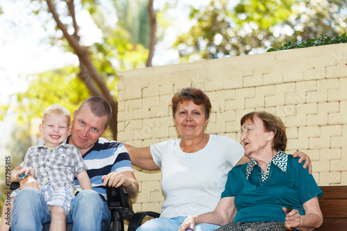 Disabled man with family outside.