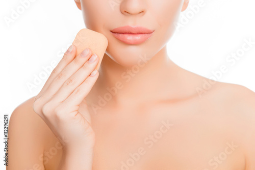 Close up portrait of woman doing maquillage with sponge