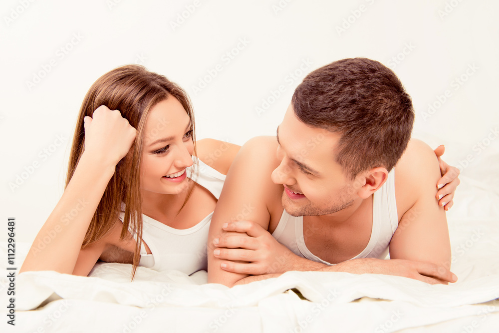 Happy attractive man and woman lying in bed and huging Happy attractive man and woman lying in bed and huging