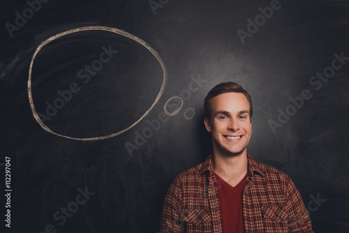 Handsome smiling young man having a mind about task