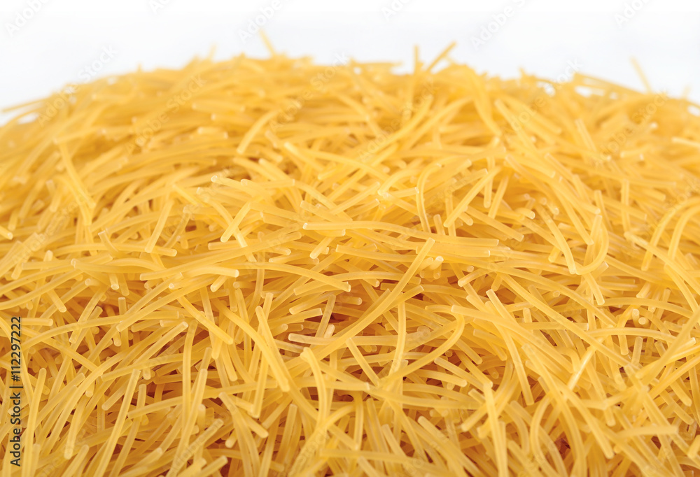 Heap of uncooked italian pasta on a white Heap of uncooked italian pasta on a white