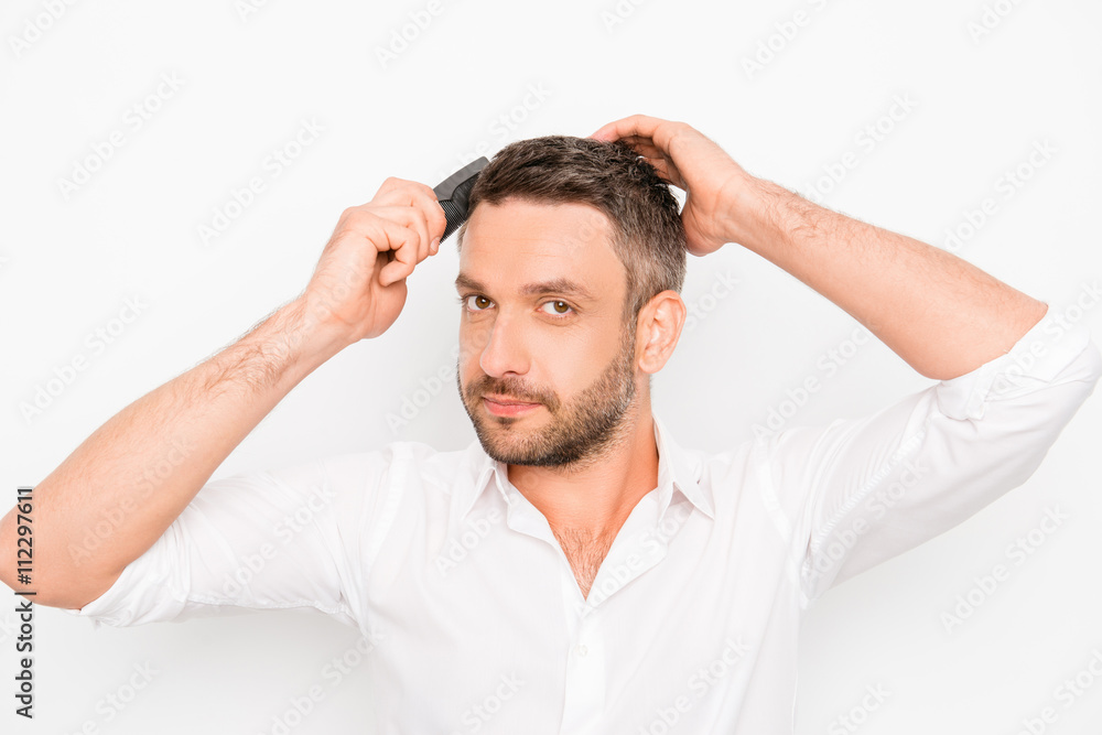 Handsome cheerful young man combing his hair with hairdresser Handsome cheerful young man combing his hair with hairdresser