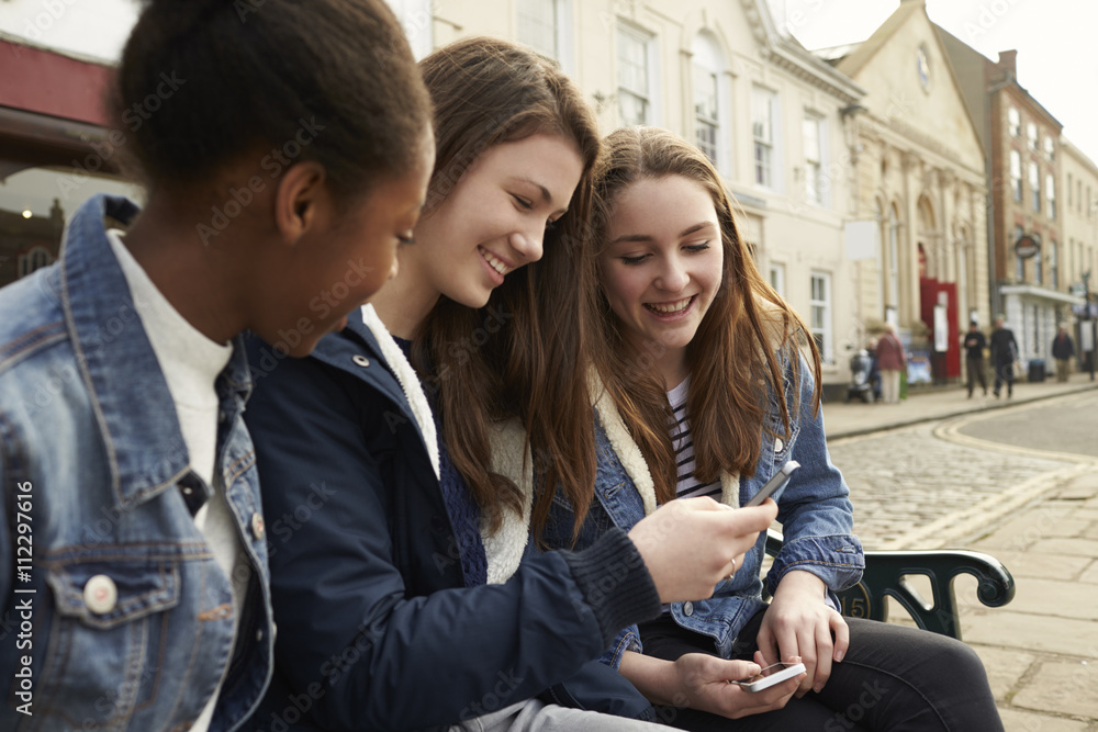 Teenage girls using mobile phone outdoors Teenage girls using mobile phone outdoors